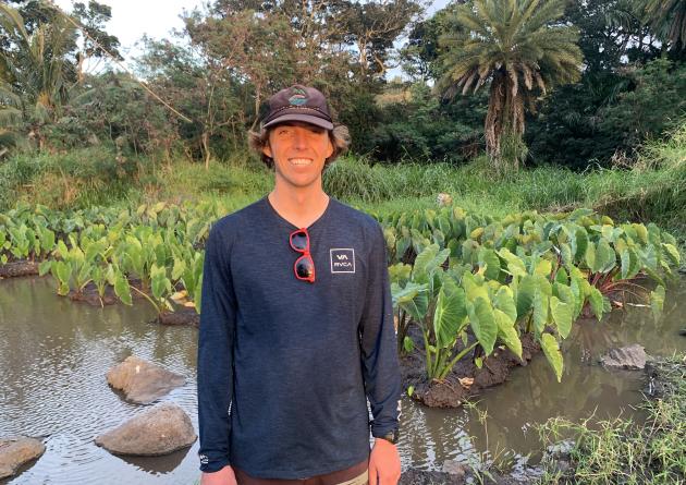 Nākoa Farrant stands in a taro field