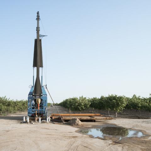 Groundwater well drilling equipment in a field