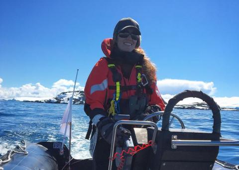 Woman steering a zodiac boat in Antarctic waters