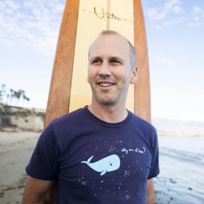 Man standing on beach with surfboard