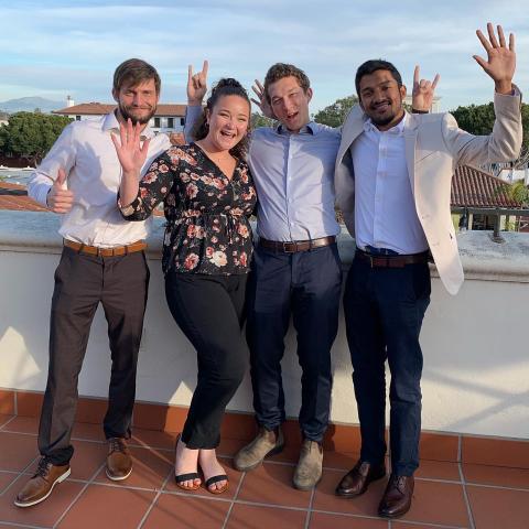 Group of four student pose together in celebration