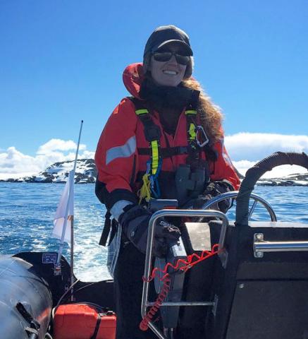 Lindsey driving a zodiac in the western Antarctic peninsula to photograph humpback whales.