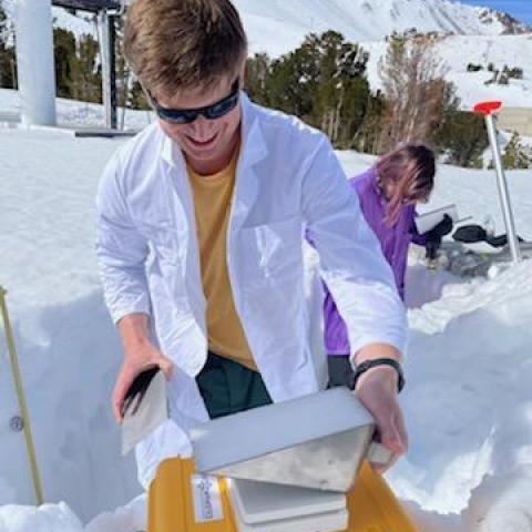 Two people taking scientific measurements in deep snow