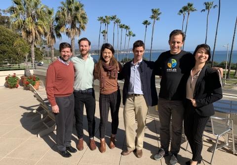 Five students stand with professor in group on terrace overlooking ocean