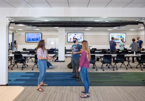 Students standing in hall by classroom