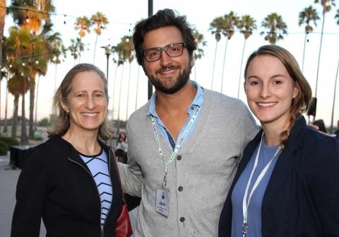 Two students and a supporter standing together smiling