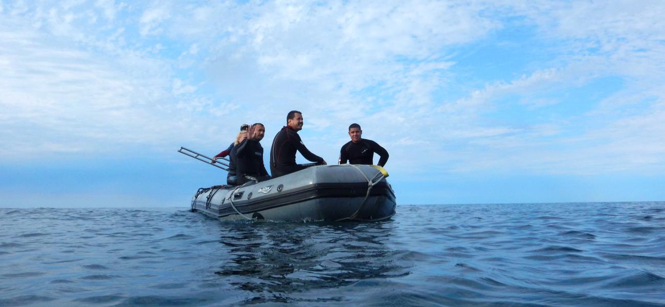 Four people in an inflatable boat on water