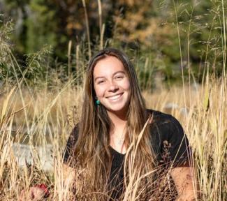 Cameran Bahnsen sits in grassland