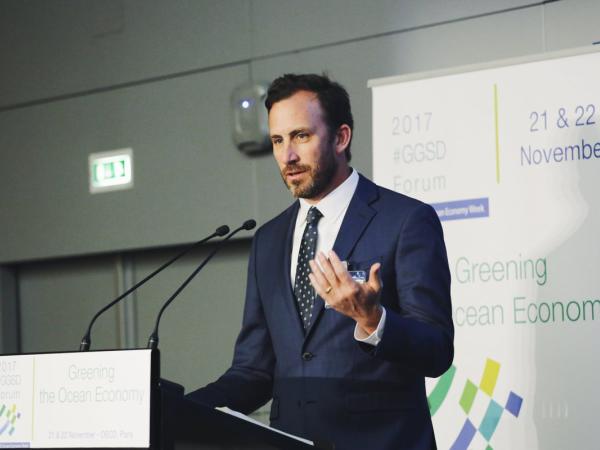 Chris Costello speaking from podium at a conference