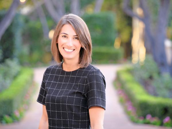 Smiling woman stands on a brick path