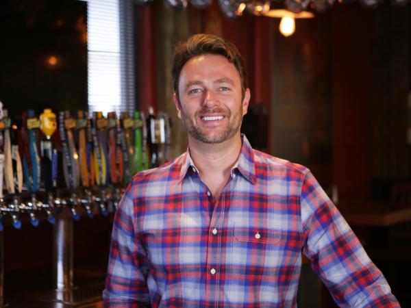 Smiling man in front of a beer tap