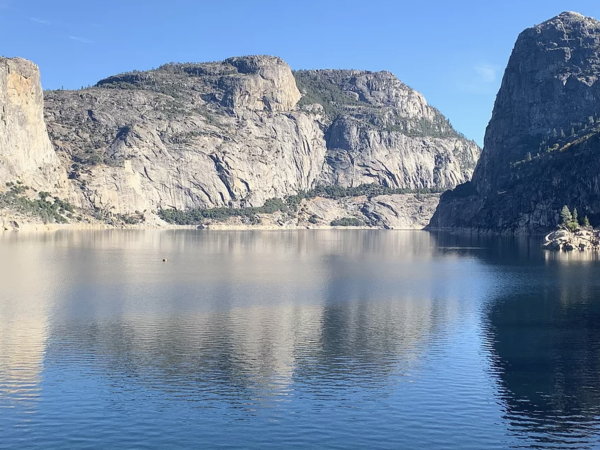 Still lake water surrounded by boulders.