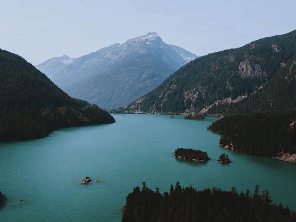 Aqua lake surrounded by forested hills