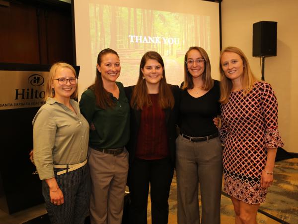 A group of five students pose after their presentation