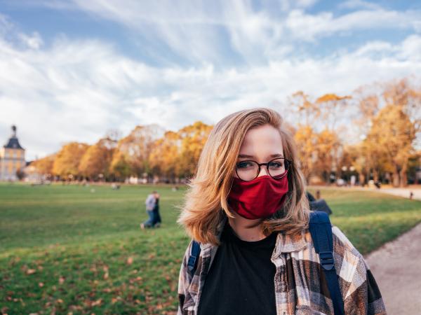 Woman on campus during fall wearing face mask
