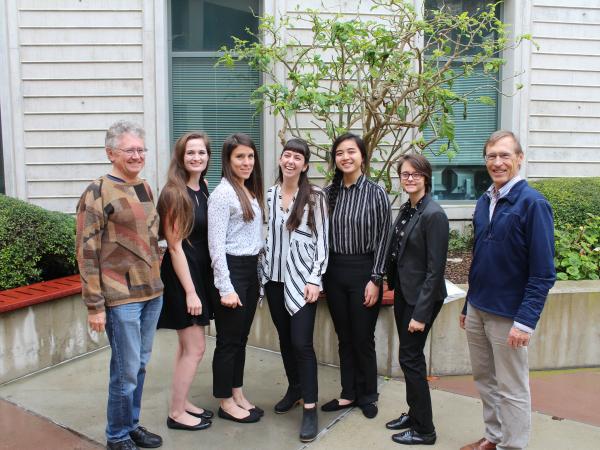 Five female students standing with two male faculty members