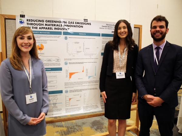 Three students standing in front of a project poster