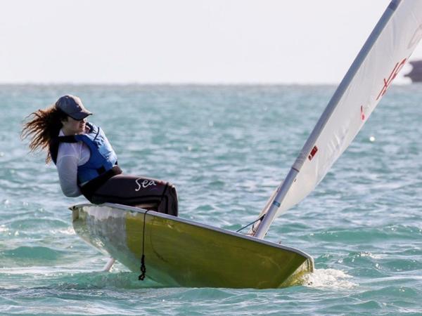 Woman maneuvering a sailboat in the ocean