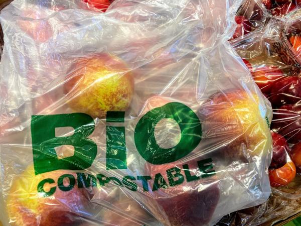 bioplastic compostable grocery bag, filled with red, yellow apples