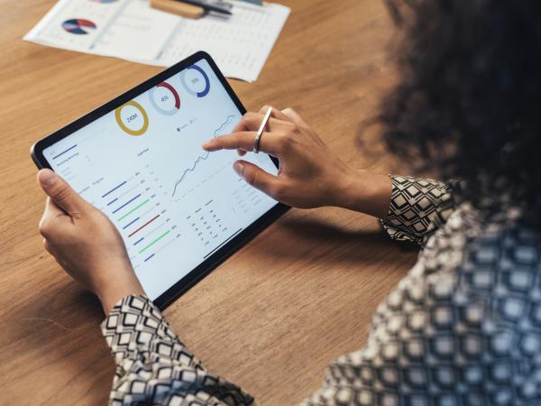 Woman holding a tablet with statistics data on the screen 