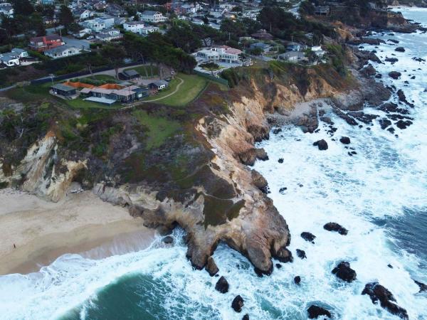 Shoreline with ocean and houses on top of cliffs