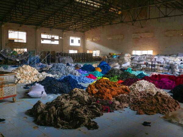 Clothing in piles on the floor of a warehouse