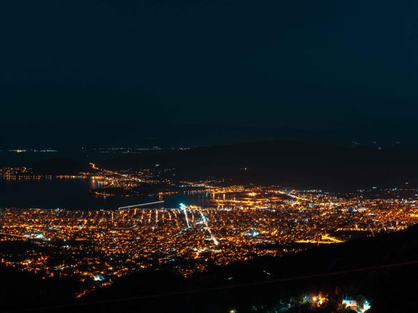 Aerial photo of a city near water at night time illuminated with lights 